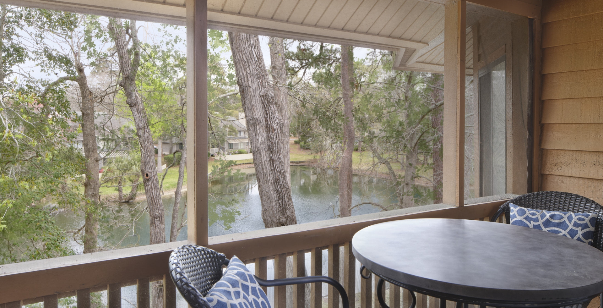 Arrowhead Court screened in porch with seating and a table