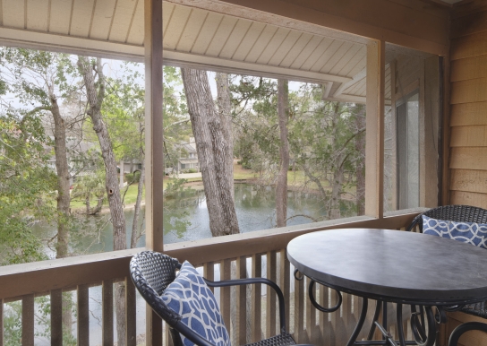 Arrowhead Court screened in porch with seating and a table