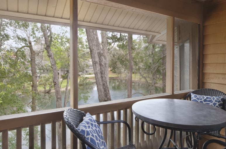 Arrowhead Court screened in porch with seating and a table