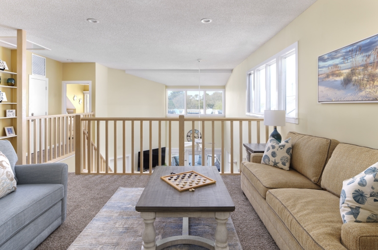 Windermere by the Sea loft area with couches and checkers on the coffee table