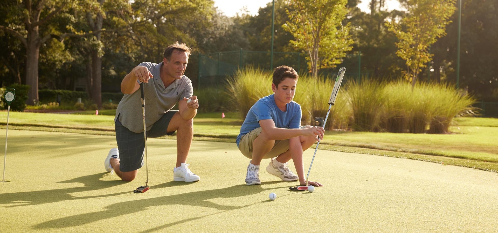 Father and son on putting green