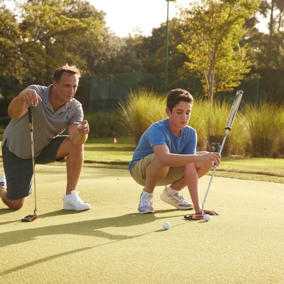 Father and son on putting green