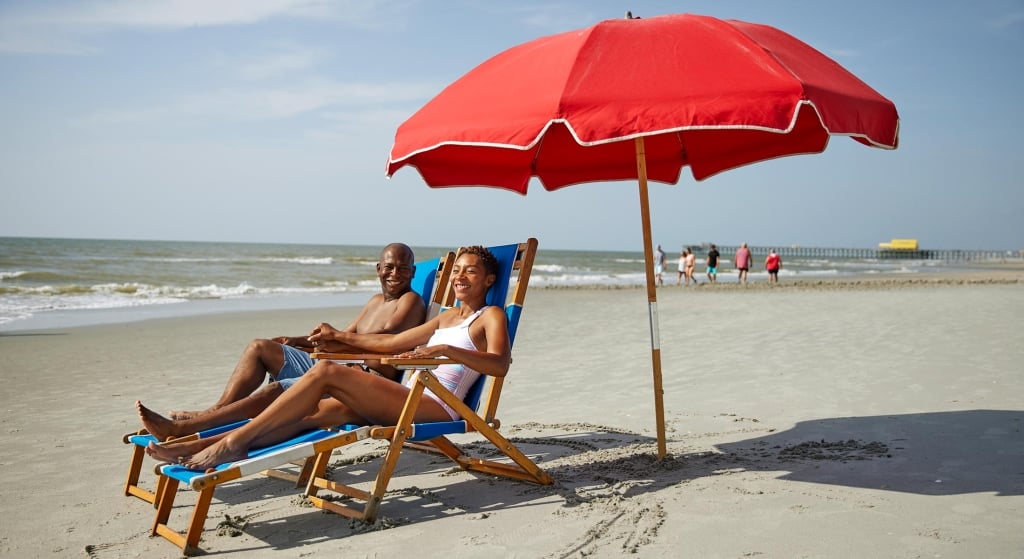 Couple under umbrella at beach