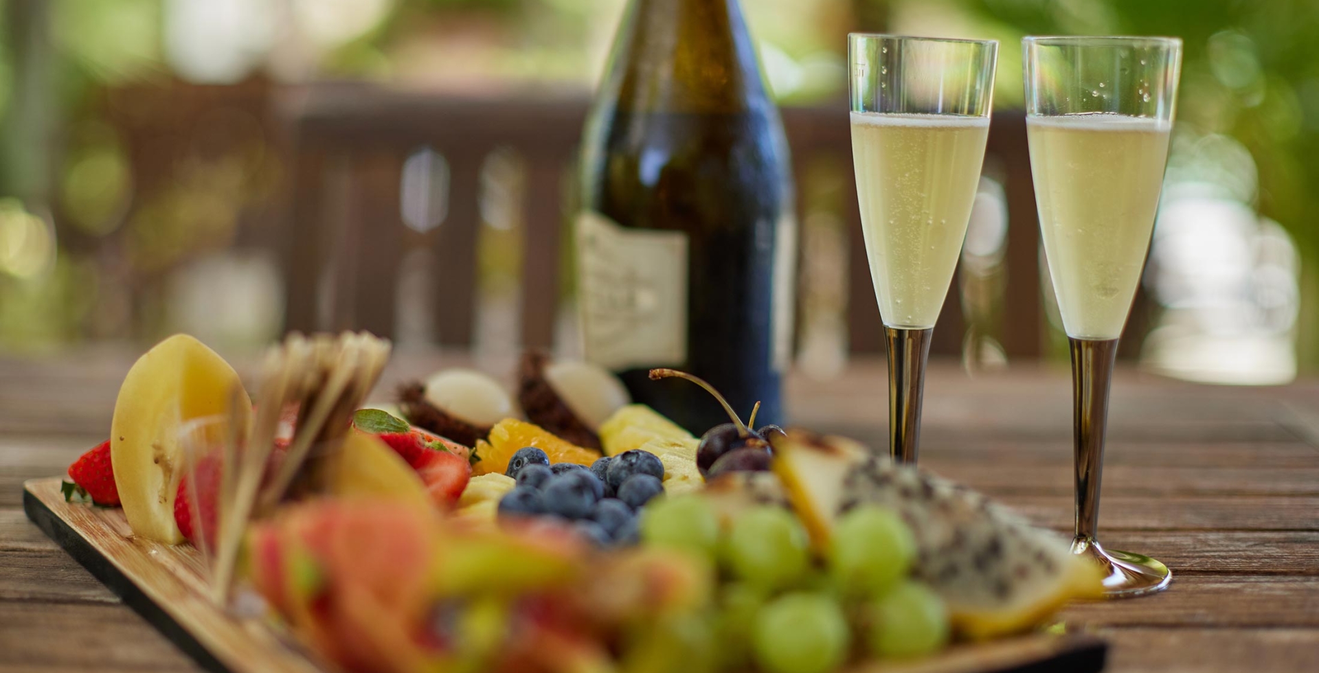Close up of a fruit tray and glasses of champagne that can be served in our Hilton Cabanas