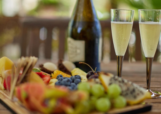 Close up of a fruit tray and glasses of champagne that can be served in our Hilton Cabanas