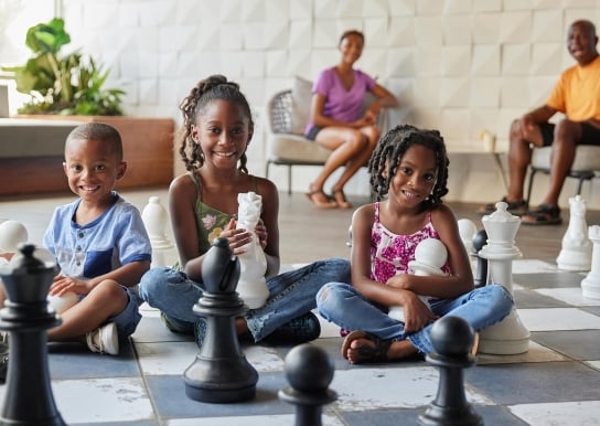 Kids playing with the giant chess set located at the Hilton
