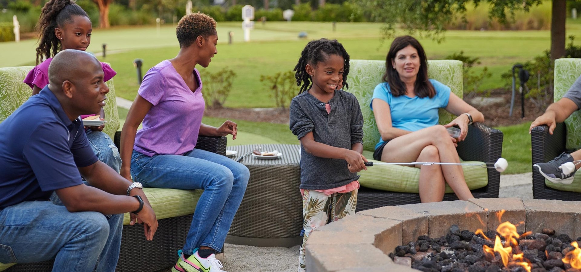 Families around fire pit and kids roasting marshmallows