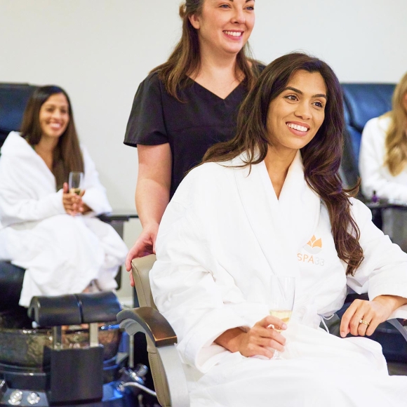 Three women at spa33 enjoying champagne and a pedicure.