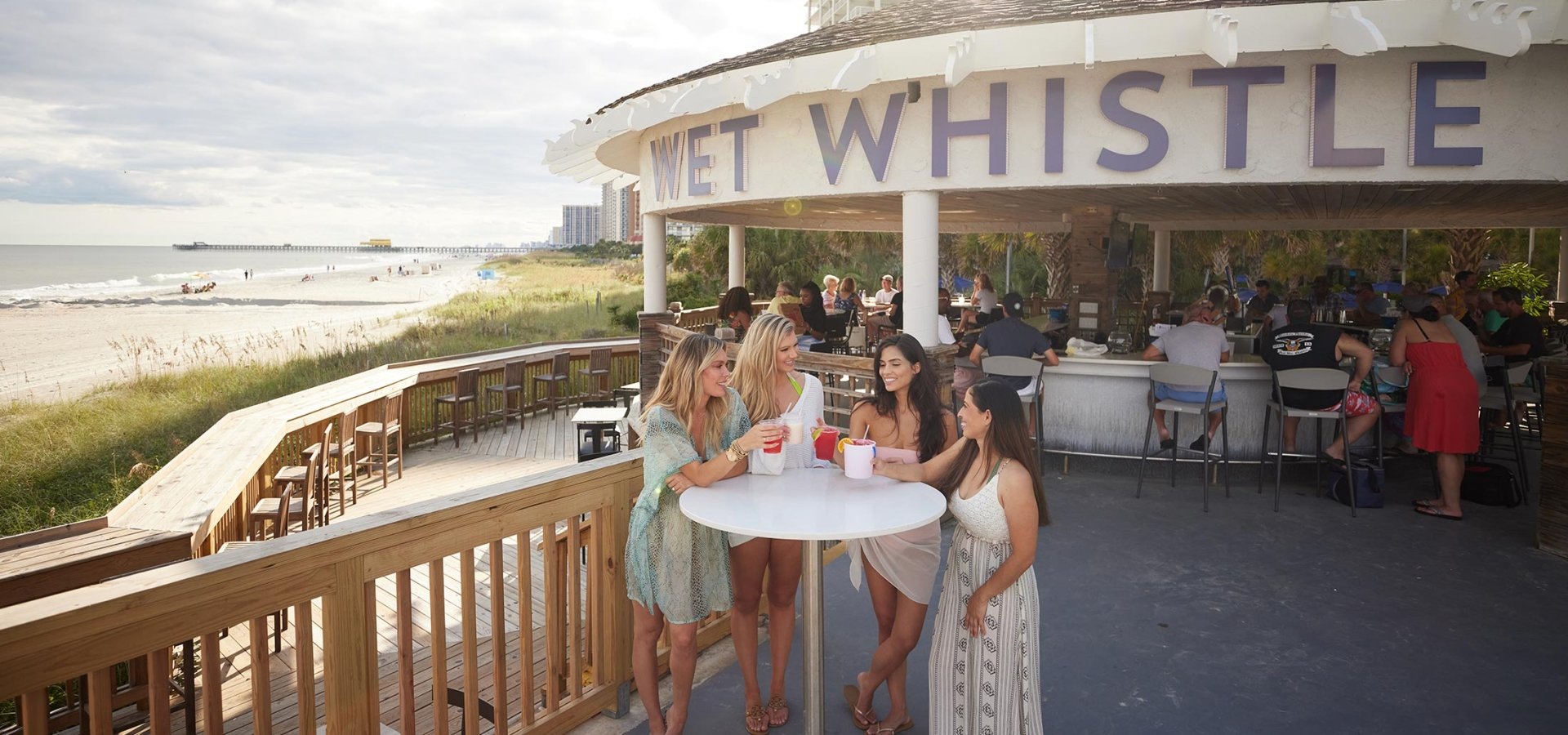 Women at table of Wet Whistle holding their cocktails