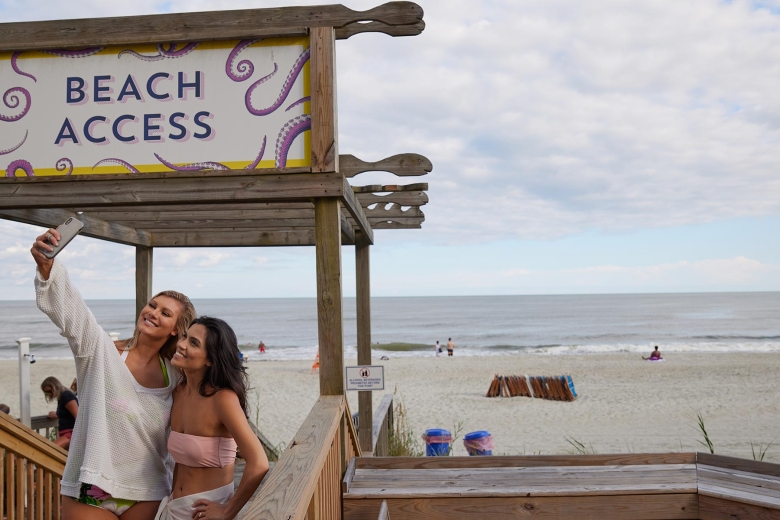 Friends taking selfie by beach entrance at Wet Whistle