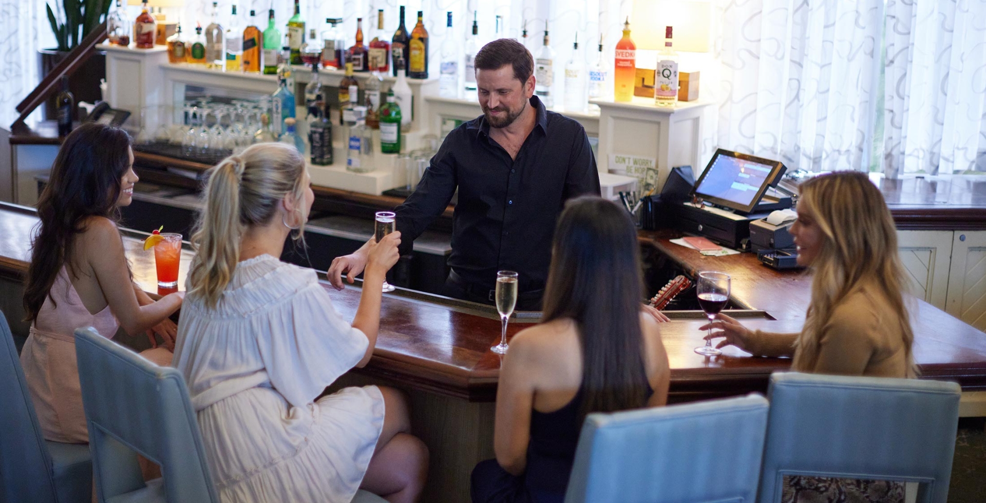 Women being served drinks at Veranda bar by bartender