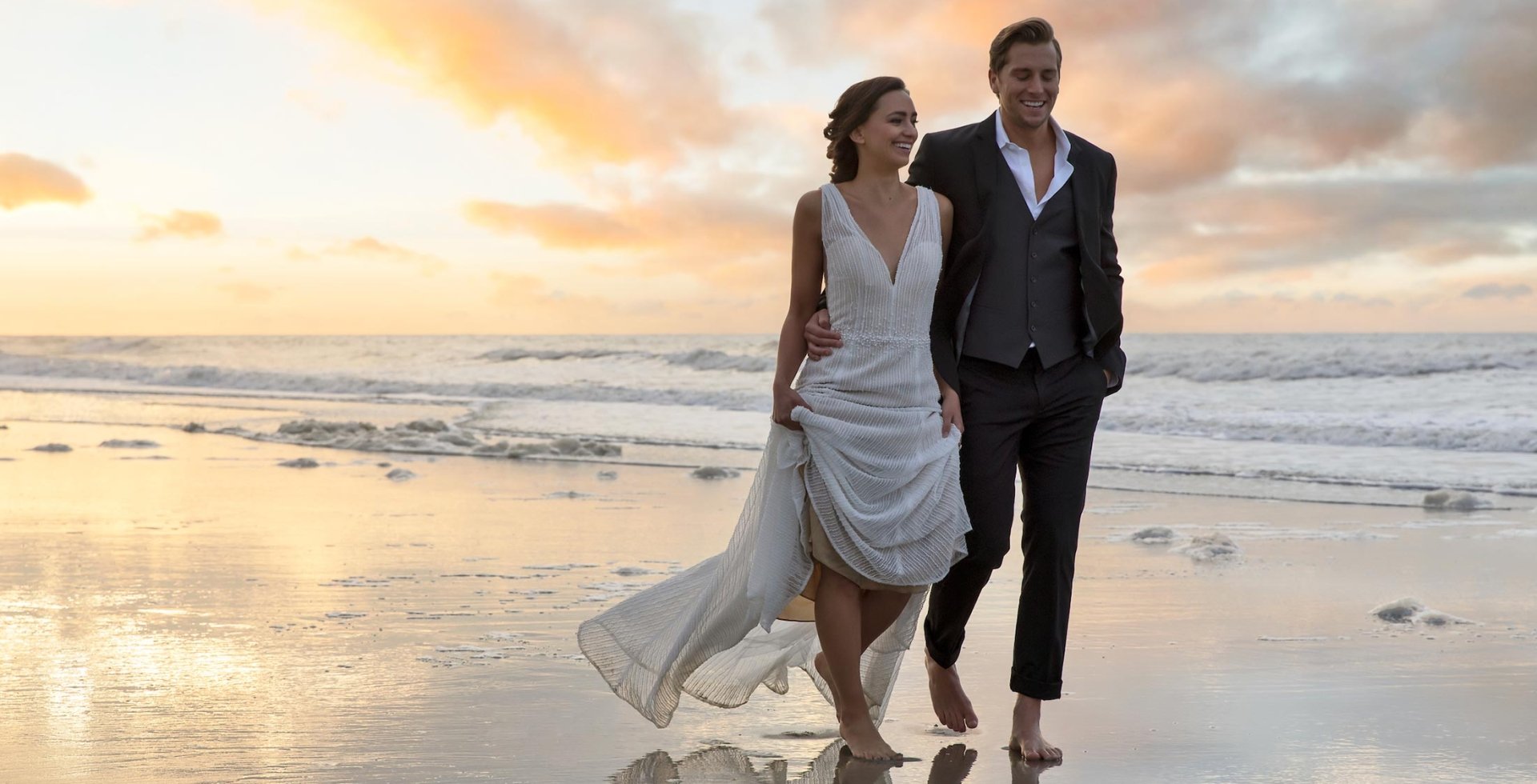 Bride and groom walking on the beach