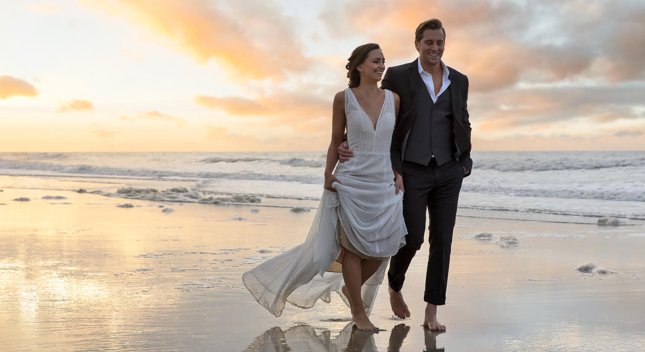 Bride and groom walking on the beach