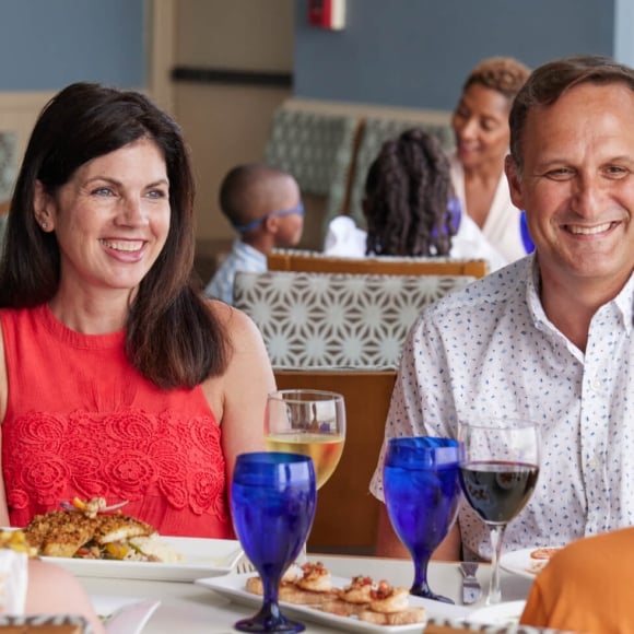 Family sitting at restaurant table and smiling