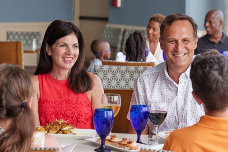 Family sitting at restaurant table and smiling