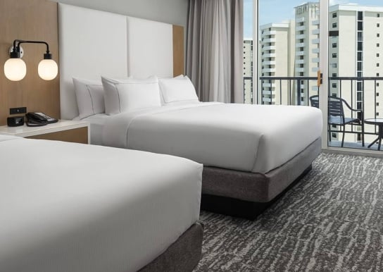 Two bedroom Hilton hotel room with a balcony and partial ocean view