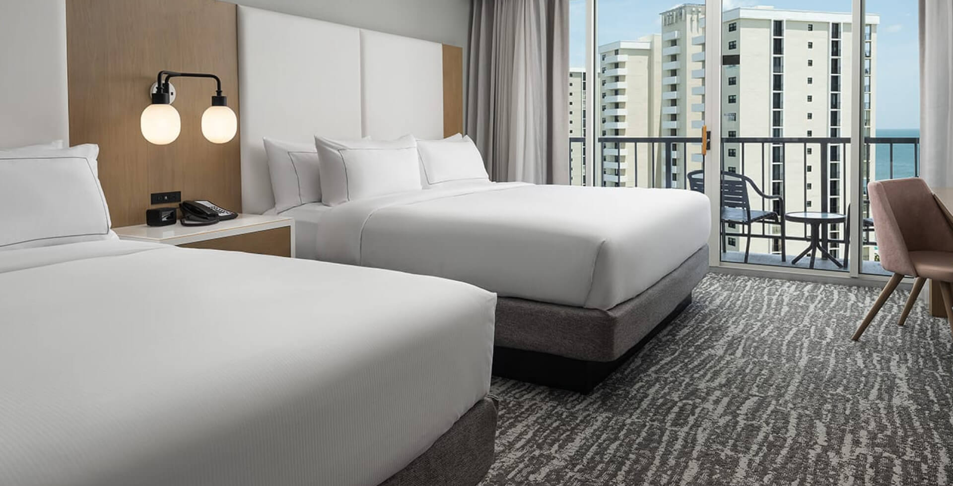 Two bedroom Hilton hotel room with a balcony and partial ocean view