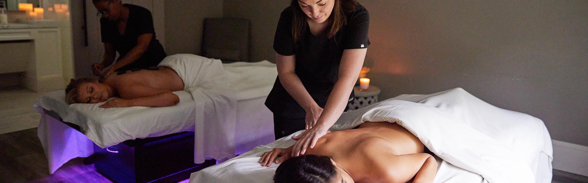 Two women receiving massages in the double bed room at Spa33