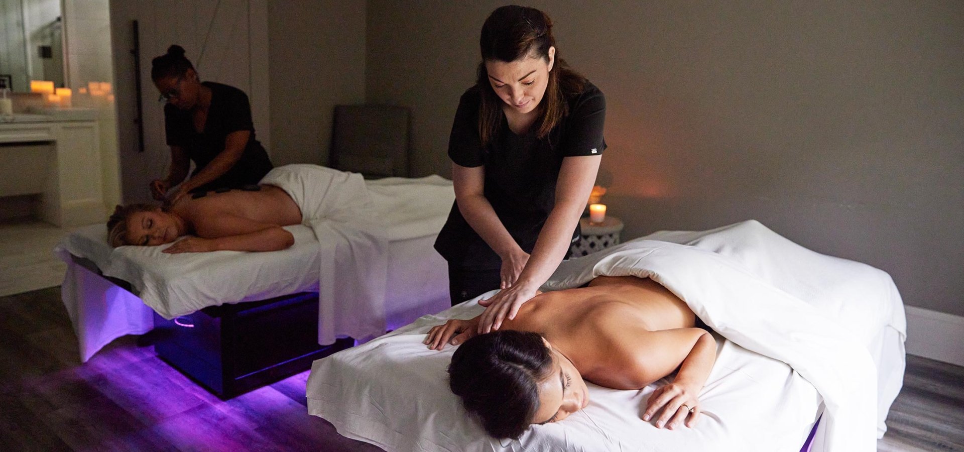 Two women receiving massages in the double bed room at Spa33