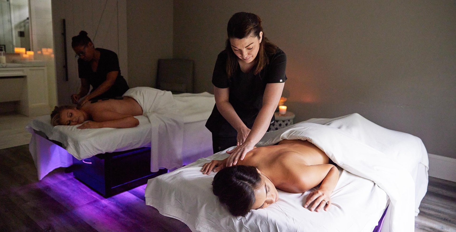Two women receiving massages in the double bed room at Spa33