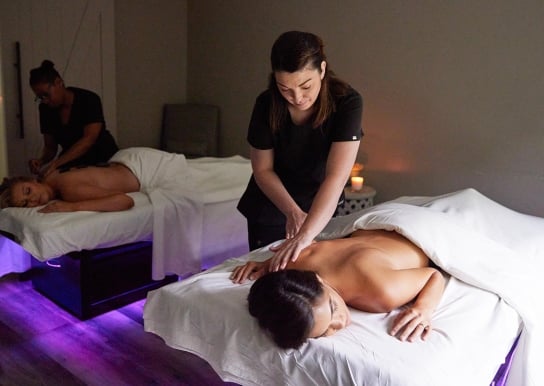 Two women receiving massages in the double bed room at Spa33