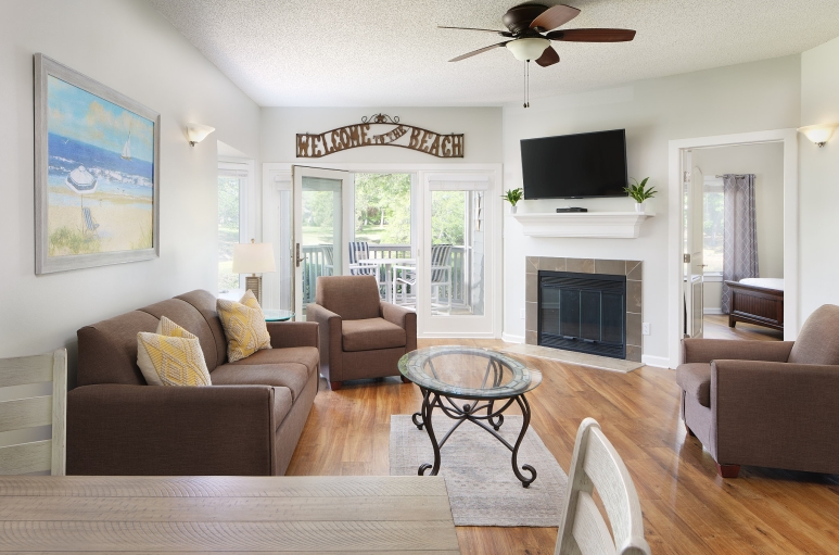 Windermere by the sea living room with a fireplace, and patio access