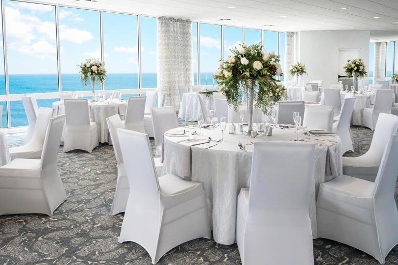 Tables set for wedding in ocean view ballroom