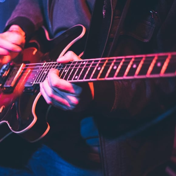 Hands playing an electric guitar