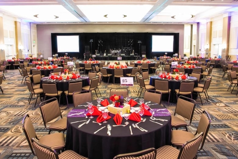 Round tables dinner set up in Hilton Palisades ballroom with a stage for a band