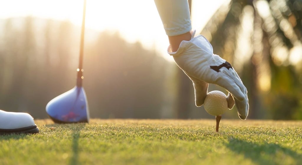 Golfer placing the ball on the tee