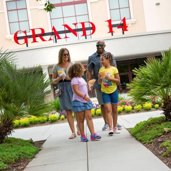 Family eating ice cream cones in front of Grand 14 Movie Theater