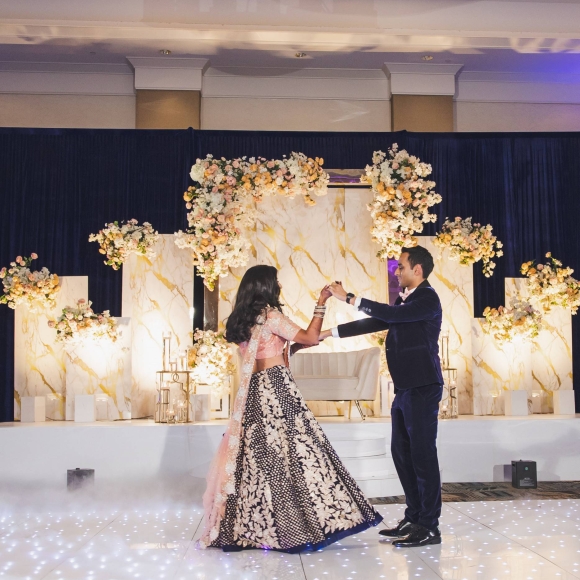 Newly married couple dances in traditional Indian wedding attire.