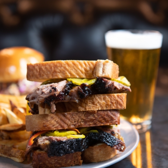 Brisket Sandwich on Texas Toast with beer in the background