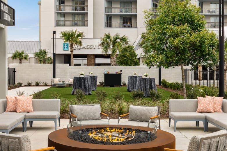 Currents Seaside Entertainment event lawn set up for a wedding cocktail reception and soft seating around a firepit