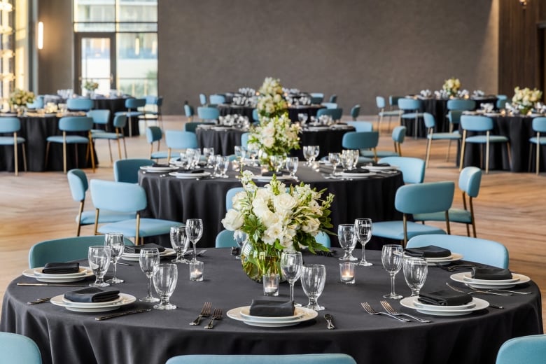 Seaside Vista ballroom set up in rounds for a wedding dinner with beautiful white flower centerpieces