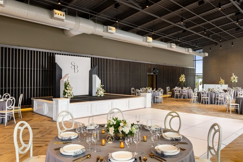 Seaside Vista set up for a wedding reception with round tables and a dance floor with a stage