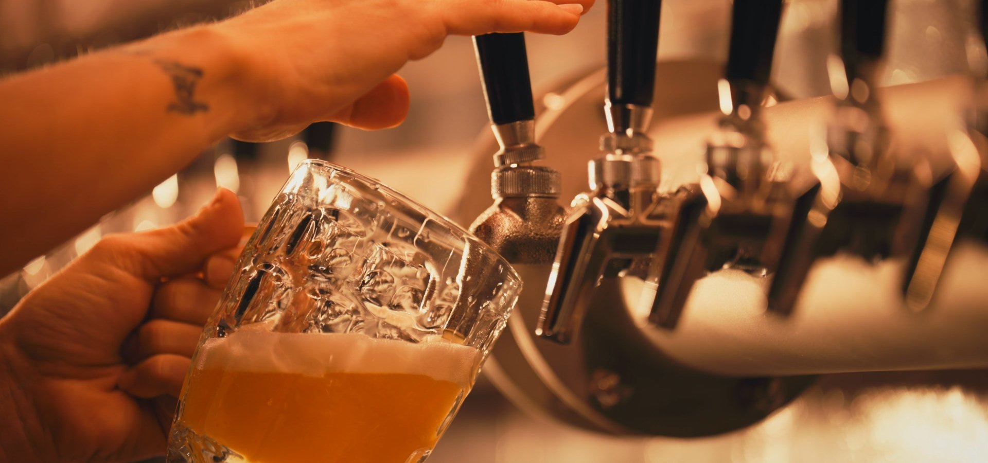 Bartender pouring beer from connected draft lines