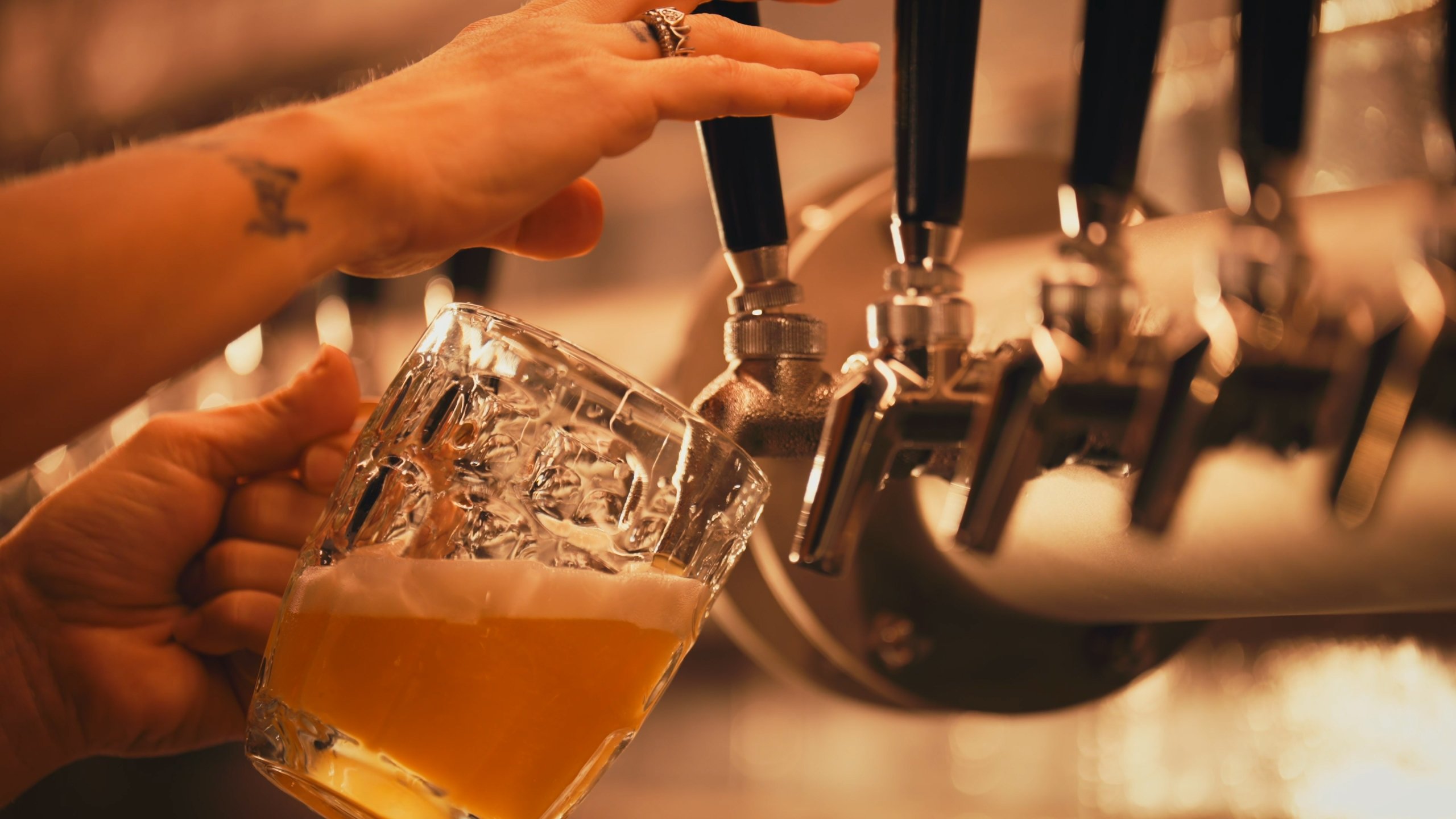Bartender pouring beer from connected draft lines
