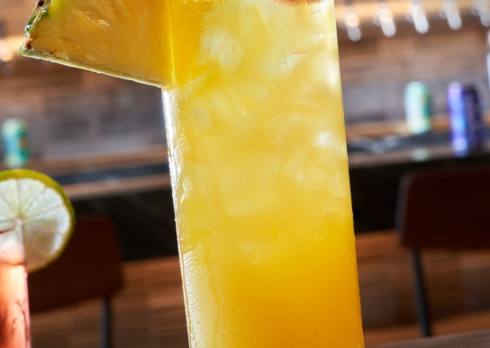 Black Drum Brewing Sandy Shandy cocktail garnished with a pineapple wedge and cherry