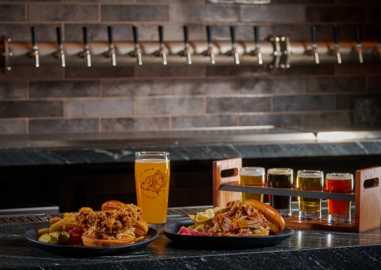 Black Drum Brewing Fried Chicken sandwich and pulled chicken sandwich with a pint of beer and a beer flight