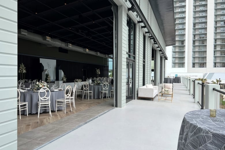 Seaside Vista wedding set up with rounds inside for dinner and the terrace set up for cocktail hour or side conversations