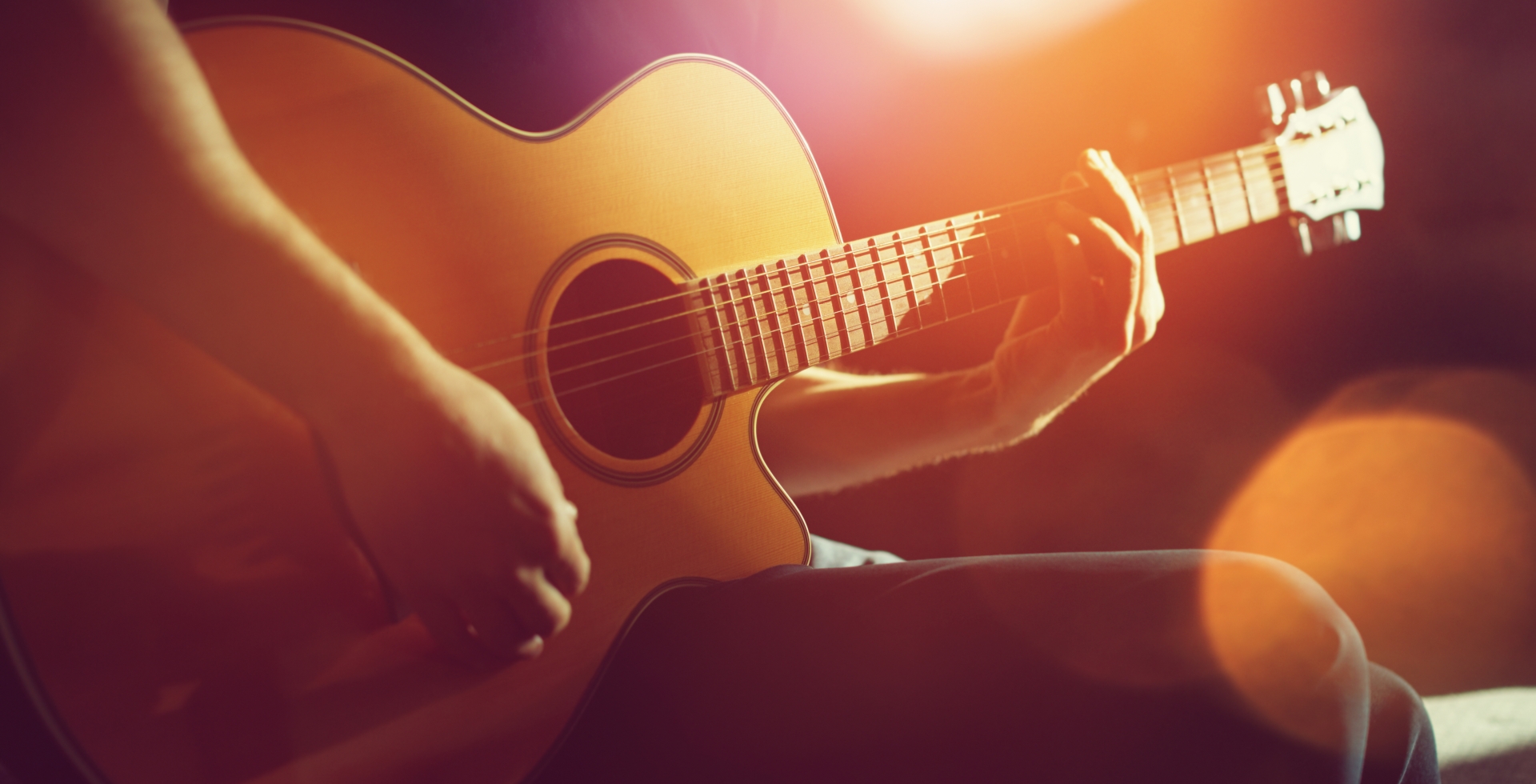 Close up of guy playing the acoustic guitar