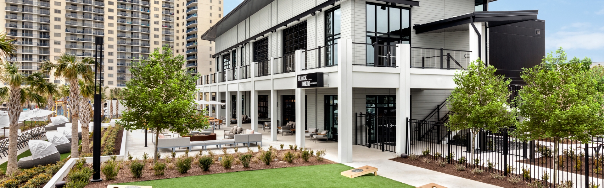 Black Drum Brewing exterior and event lawn with cornhole boards