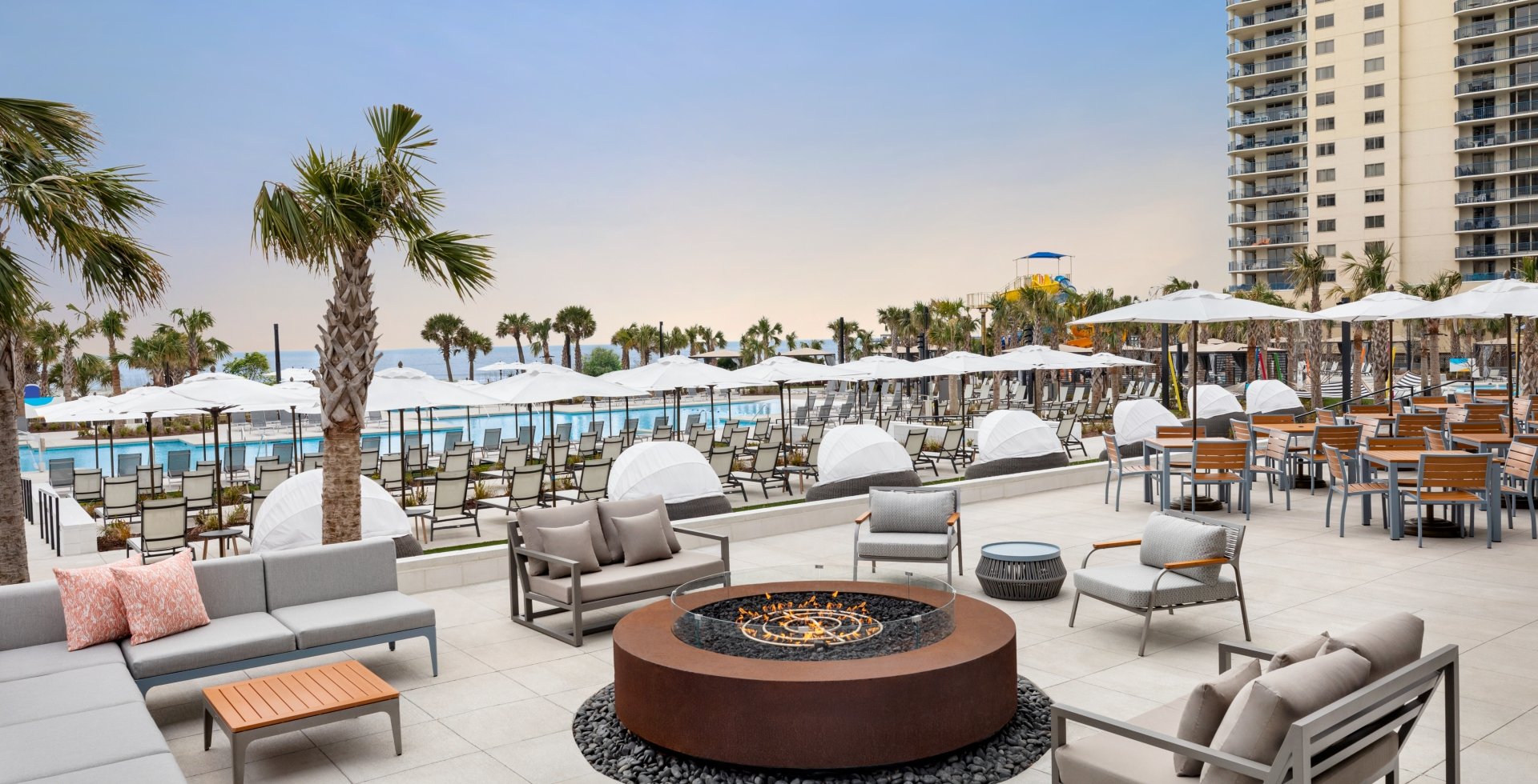 Black Drum exterior patio. Soft seating around a firepit.