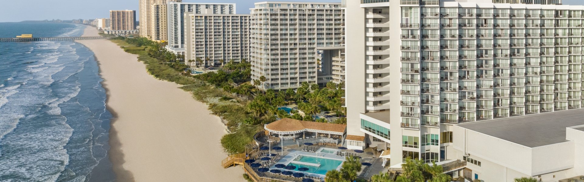 An aerial shot of Kingston Resorts starting at Hilton and looking down towards The Apache Pier