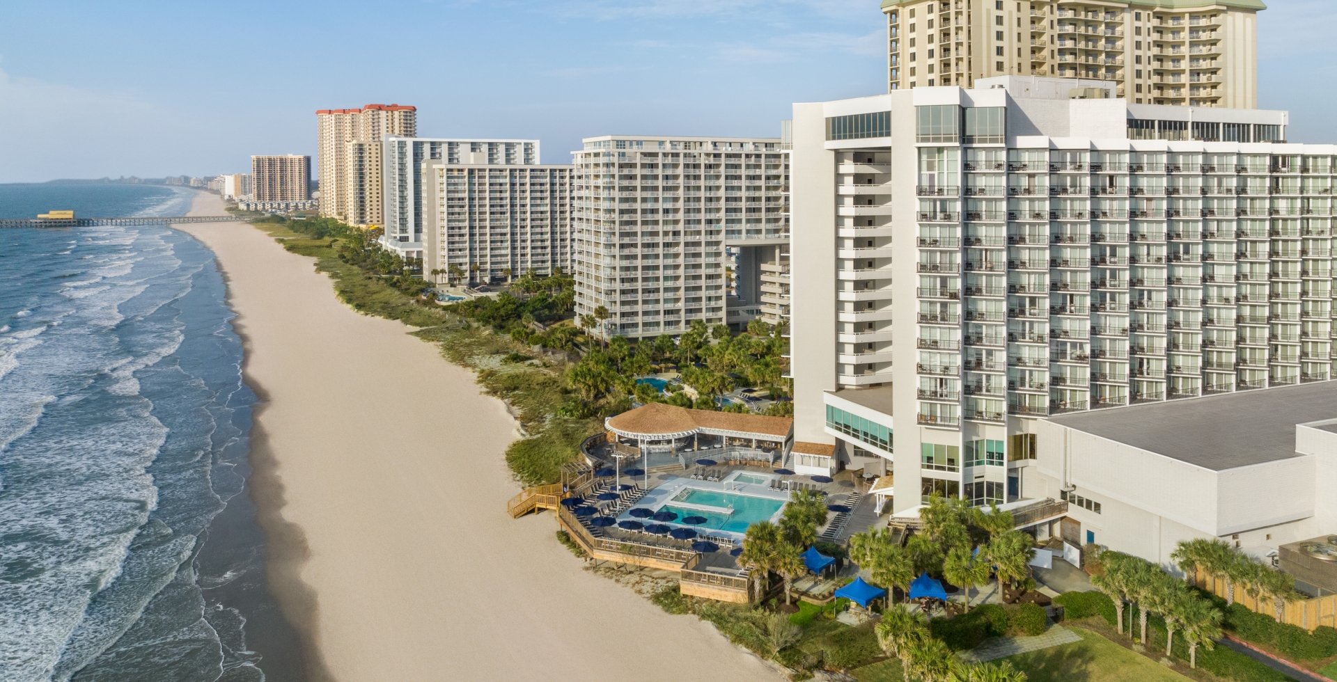 An aerial shot of Kingston Resorts starting at Hilton and looking down towards The Apache Pier