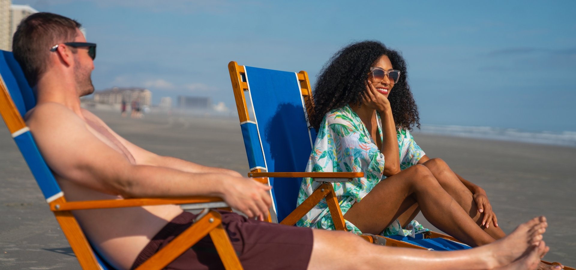 Couple sitting on the beach in lounge chairs