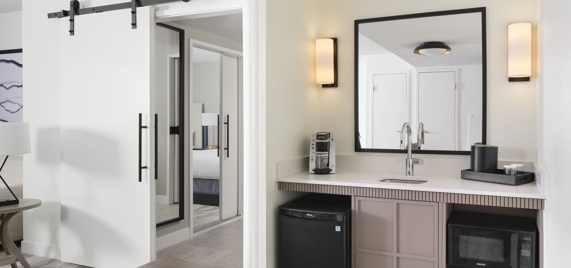 Embassy Suites mini kitchen area with a mini fridge, microwave, sink, and coffee maker