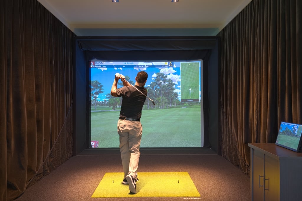 A guy using one of the golf simulators at 78Fitness