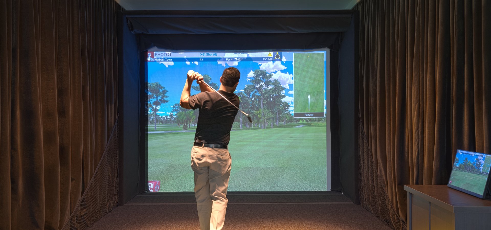 A guy using one of the golf simulators at 78Fitness